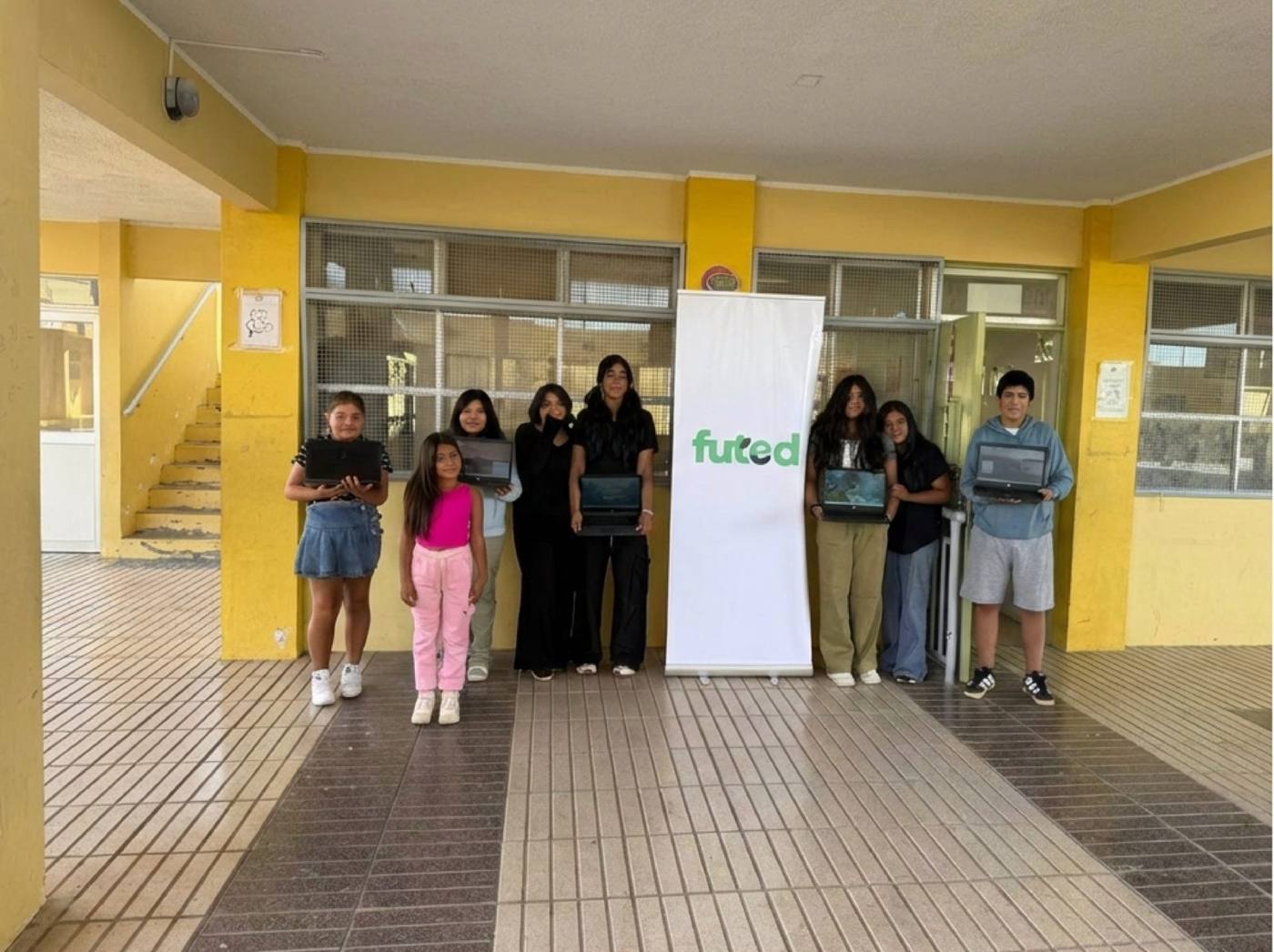 Estudiantes recibiendo computadores reacondicionados donados por FUTED en su escuela